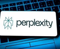 Celular com logotipo da Perplexity na tela em cima de teclado de notebook