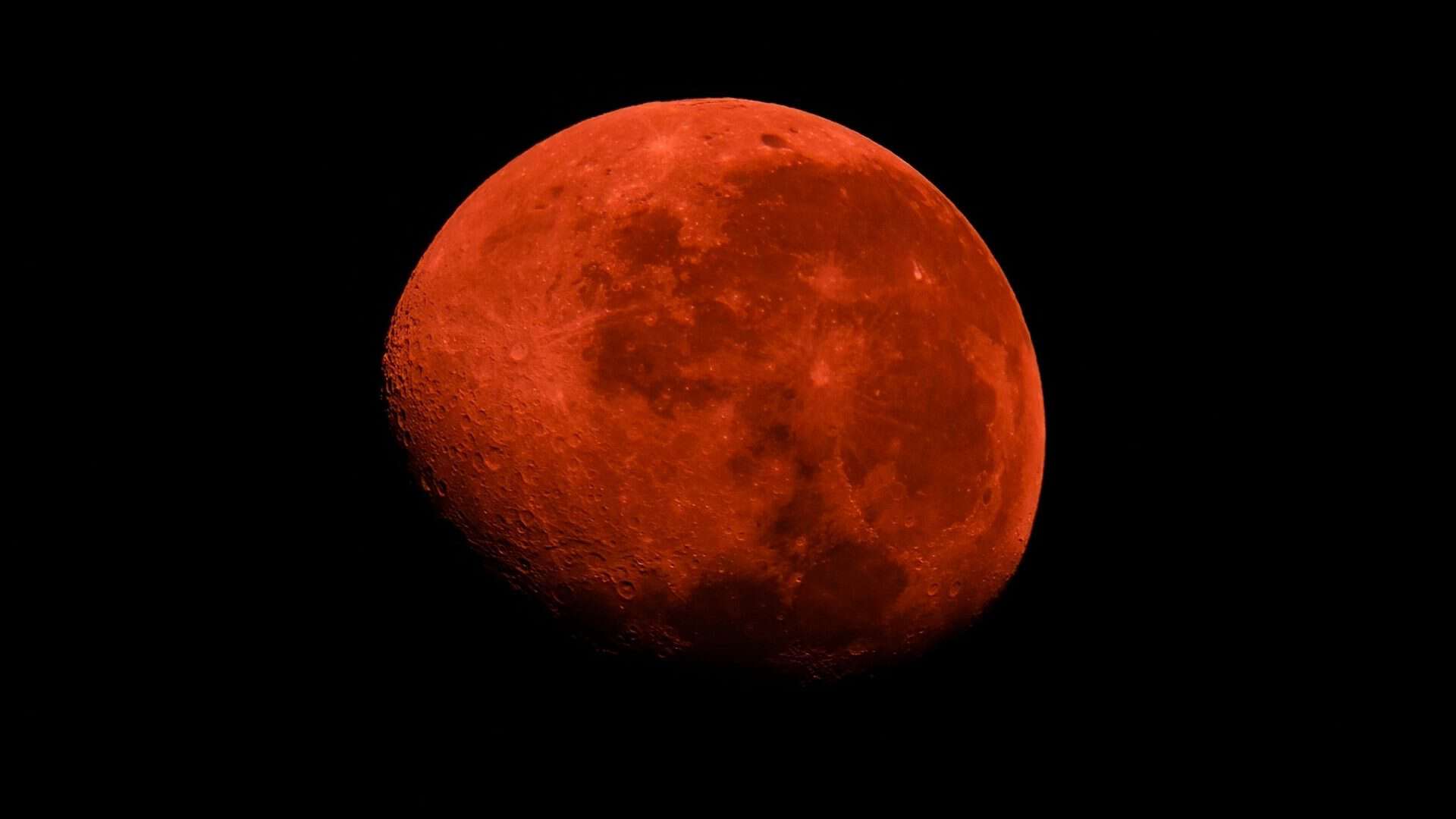 Uma imagem impressionante de um eclipse da Super Lua de Sangue no céu noturno, com a lua cheia brilhando em um tom vermelho-sangue