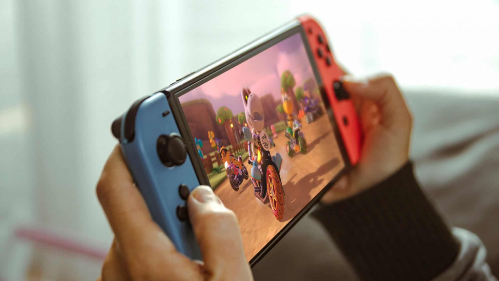 Jovem brincando com um console portátil Nintendo Switch.