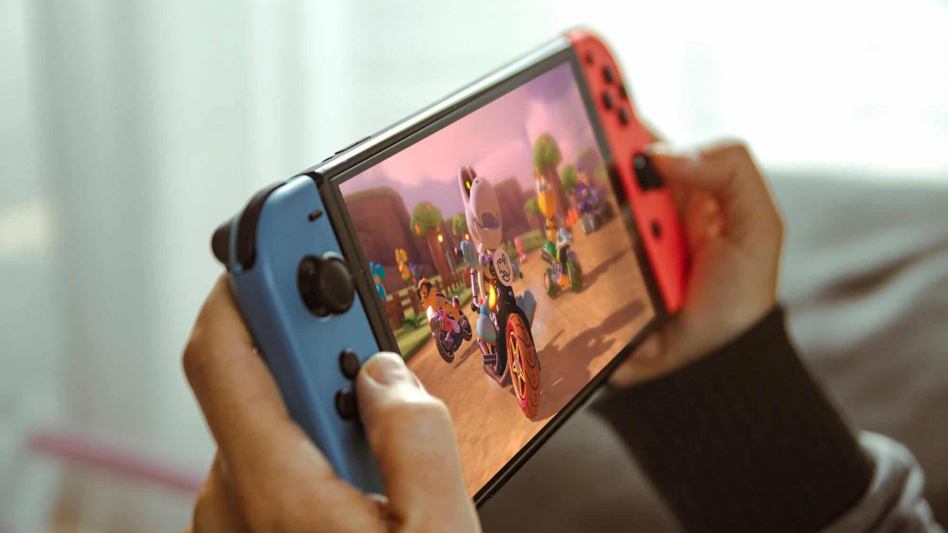 Jovem brincando com um console portátil Nintendo Switch.