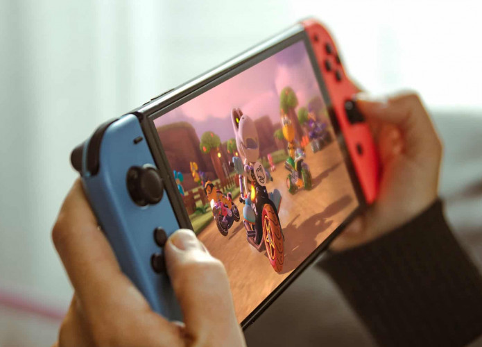 Jovem brincando com um console portátil Nintendo Switch.