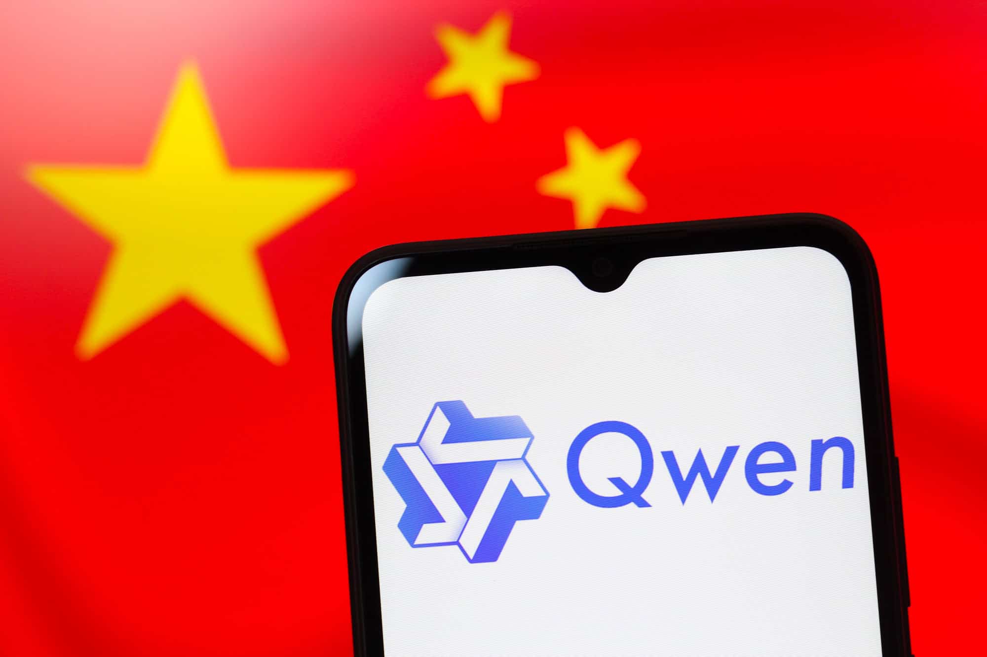 logo do qwen em um celular sobre bandeira da china
