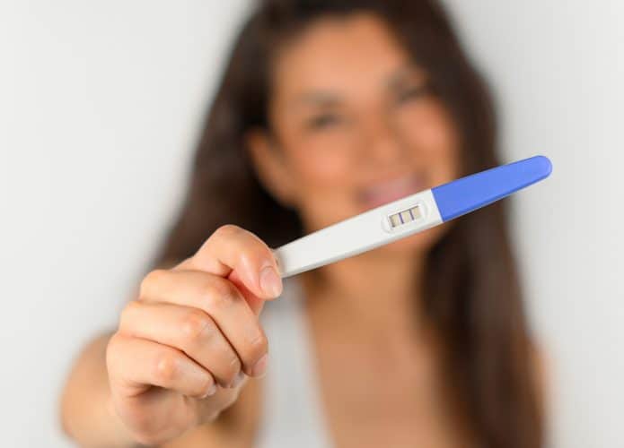 Mulher segura teste de gravidez positivo