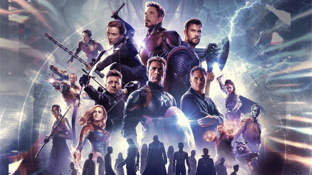 Cena do filme "Vingadores: Ultimato", mostrando os heróis da Marvel reunidos em um campo de batalha. Capitão América, Thor e Homem de Ferro estão em destaque, prontos para enfrentar Thanos, com um cenário de destruição ao fundo.