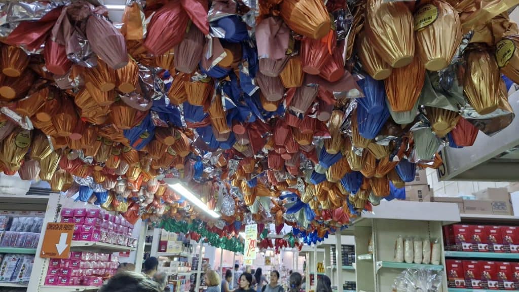 Imagens de corredor de supermercado com ovos de páscoa suspensos no alto.