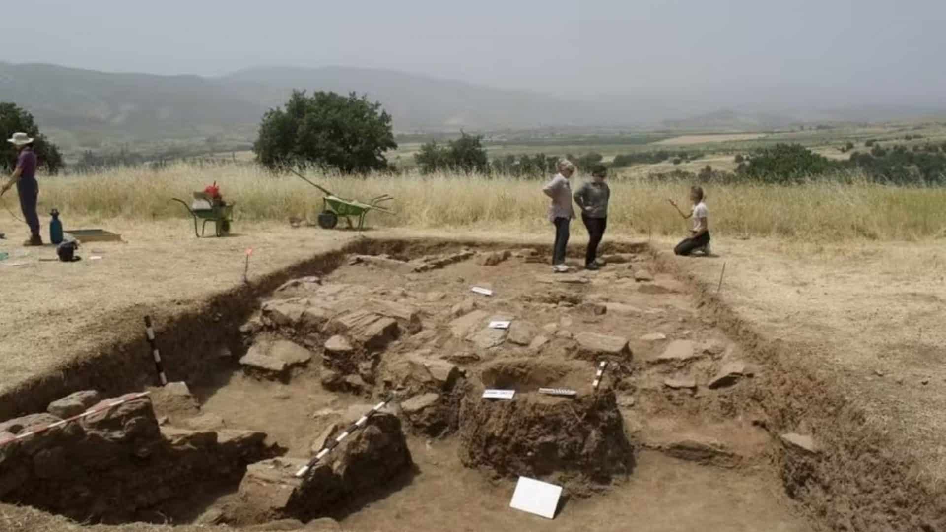 Grupo de arqueólogos em frente a um sítio arqueológico na Macedônia