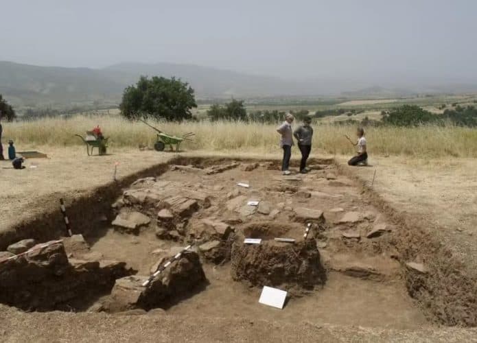 Grupo de arqueólogos em frente a um sítio arqueológico na Macedônia