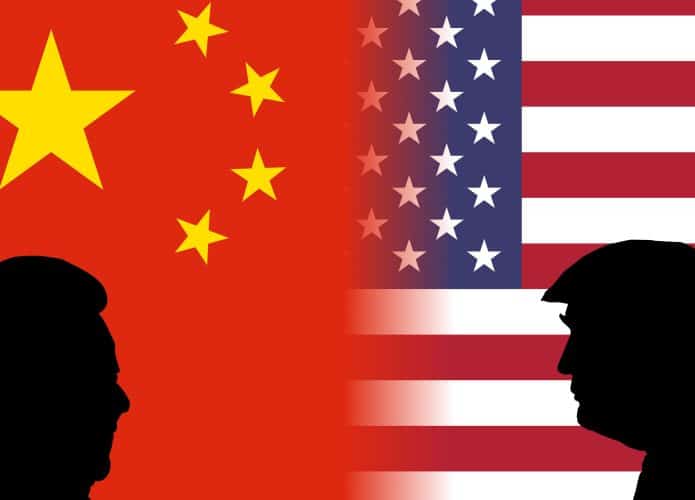 Silhuetas de Xi Jinping e Donald Trump na frente de bandeiras da China e dos Estados Unidos, respectivamente