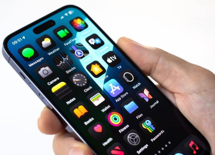 Mão de homem segurando isolado Apple iPhone 15 Pro Max com tela inicial IOS 18 na tela
