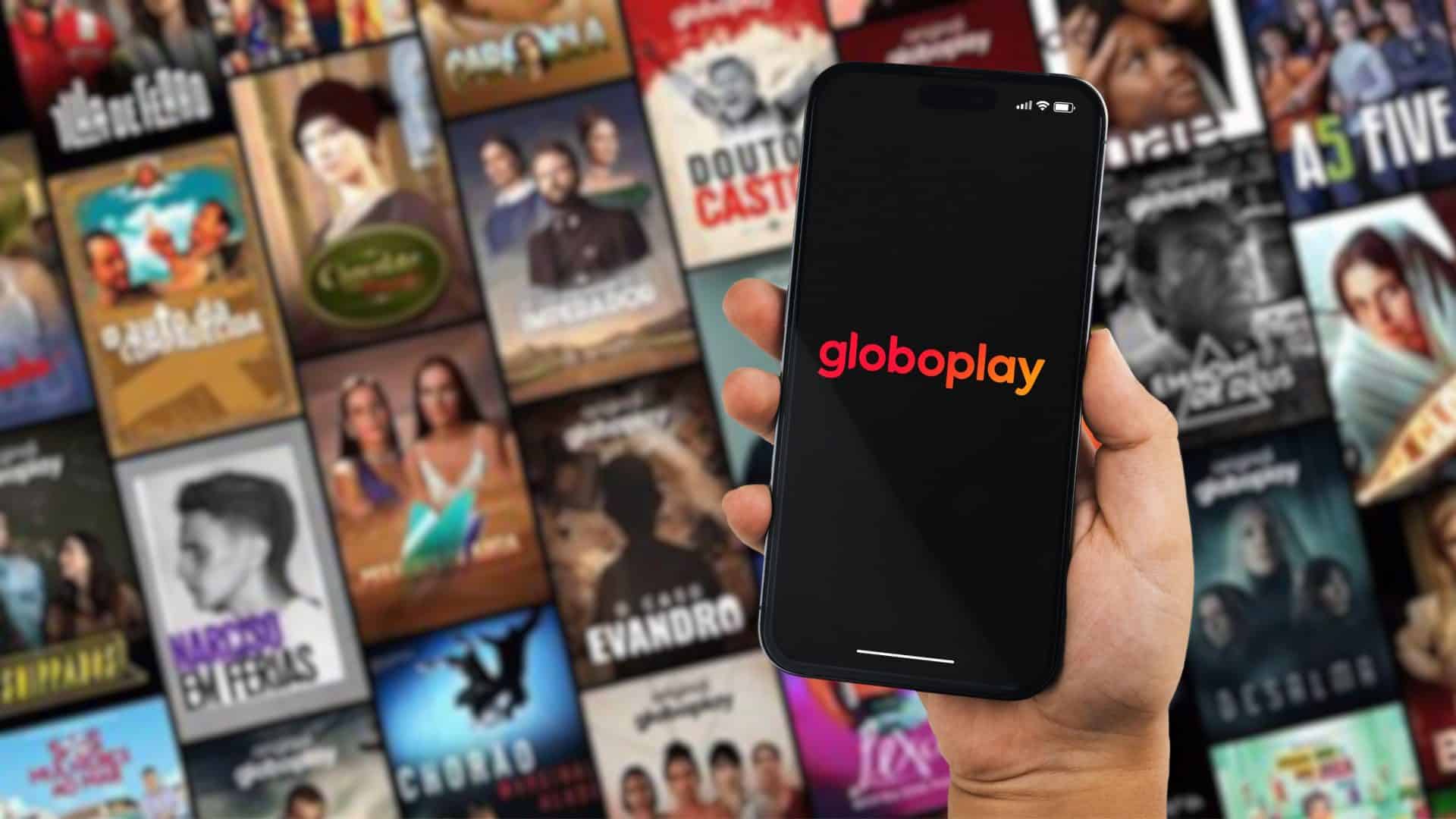 Menino segurando um smartphone iPhone 14 Pro com o aplicativo de streaming Globoplay na tela. Website desfocado ao fundo. Rio de Janeiro, RJ, Brasil. Outubro de 2022
