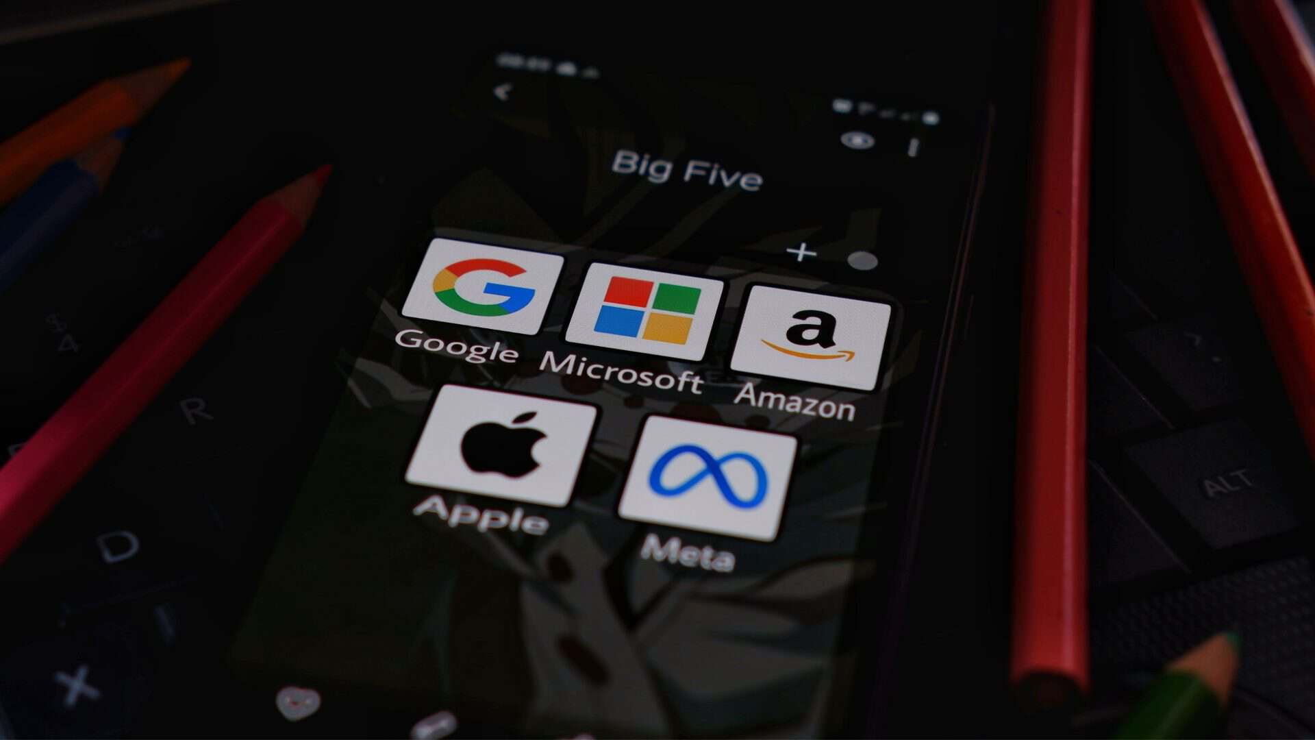 Ícones de aplicativos das big techs Google, Microsoft, Amazon, Apple e Meta numa pasta na tela inicial de um iPhone