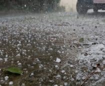 Rua cheia de pedrinhas de gelo durante chuva de granizo