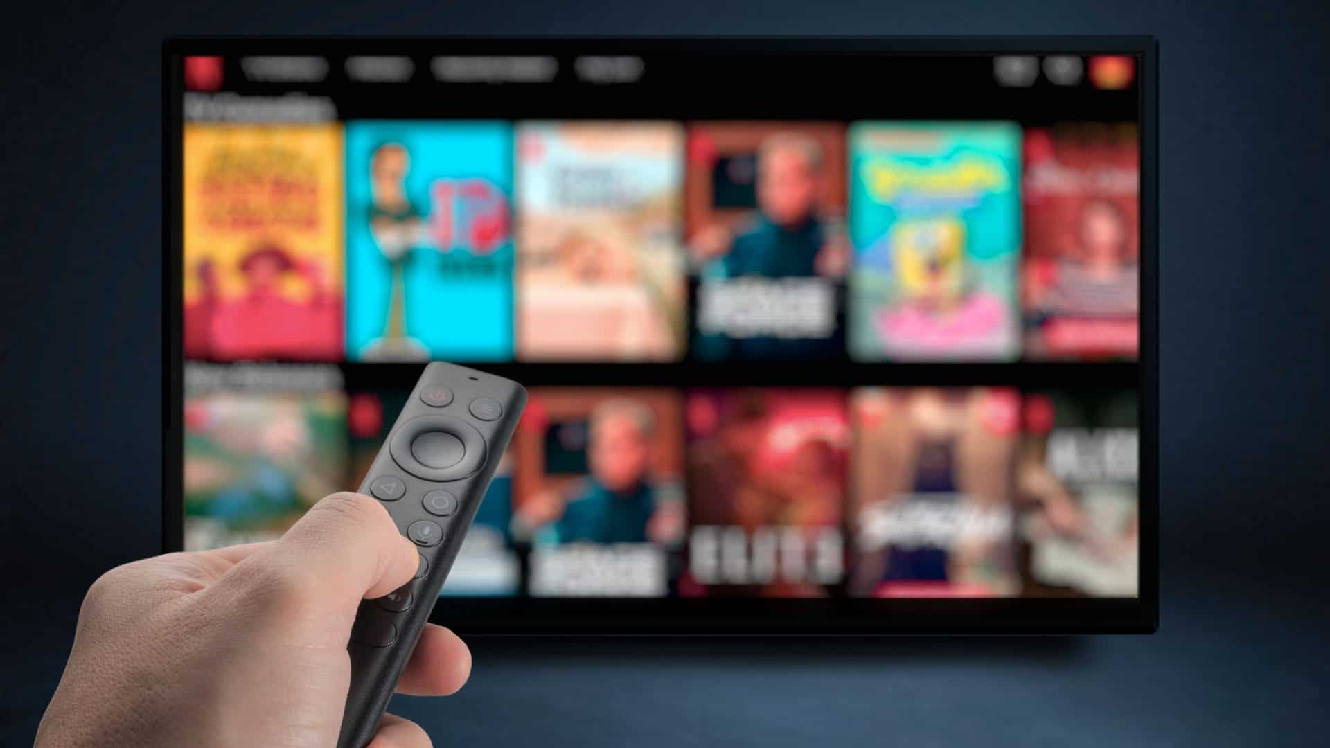 Pessoa apontando controle para TV com serviço de streaming aberto