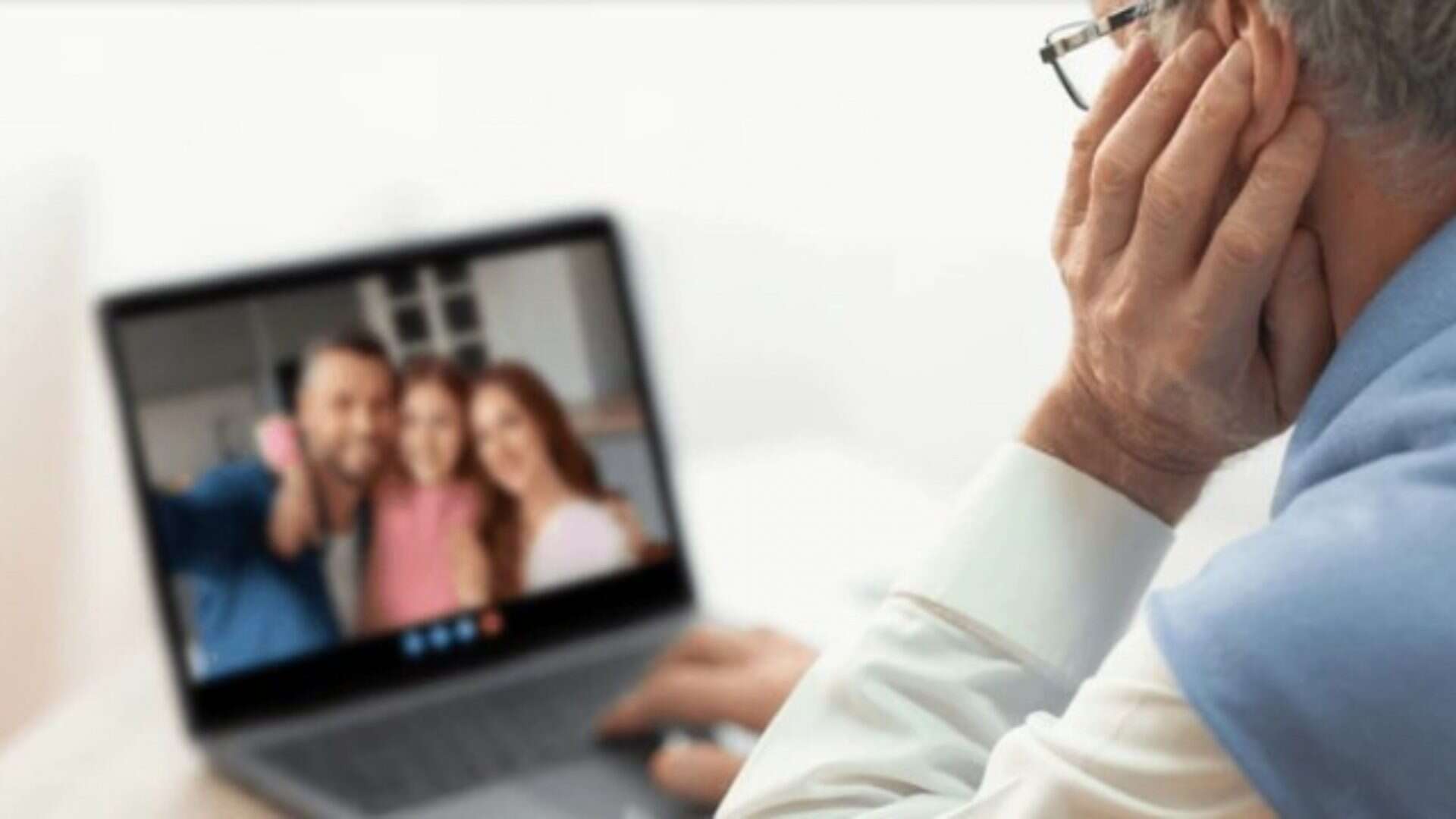 senhor de idade vendo foto da familia no computador