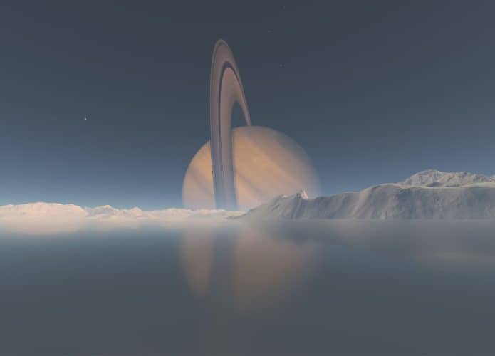 Montanhas e mar de metano em Titã, com vista de Saturno ao fundo