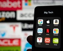 Logos de big techs ao fundo, desfocado, e à frente, em um smartphone