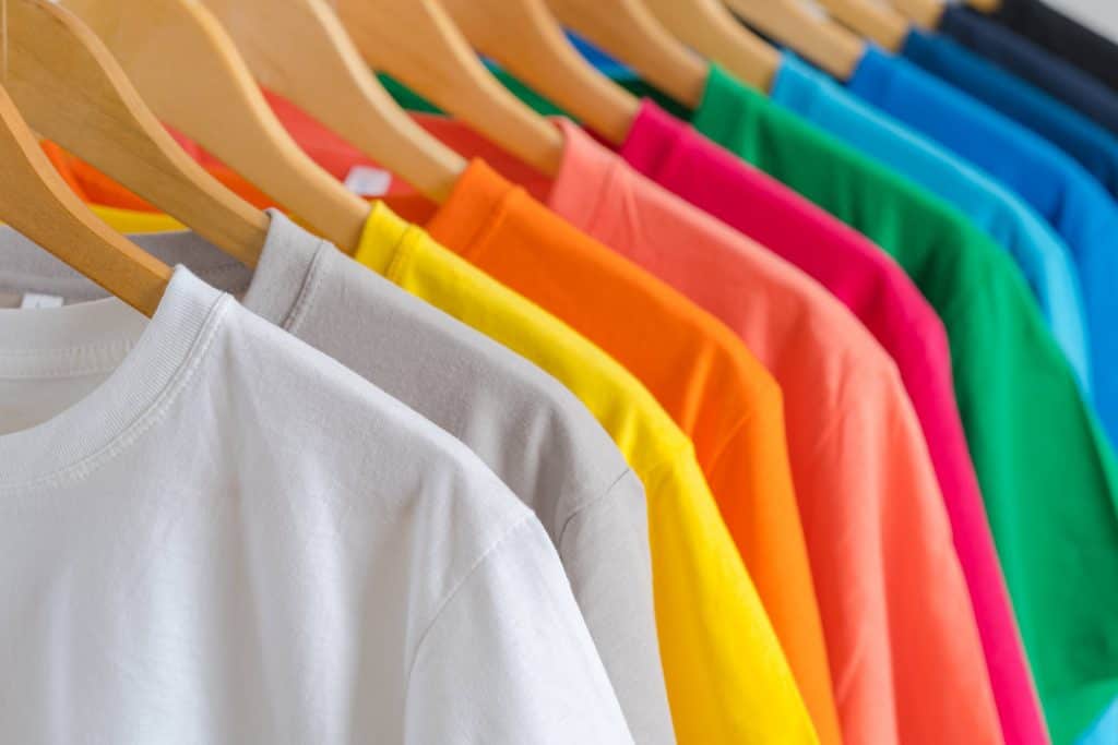 Camisetas de algodão dispostas em uma arara de roupas