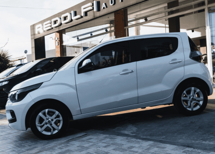 Foto de um Fiat Mobi e outros veículos em frente a uma concessionária