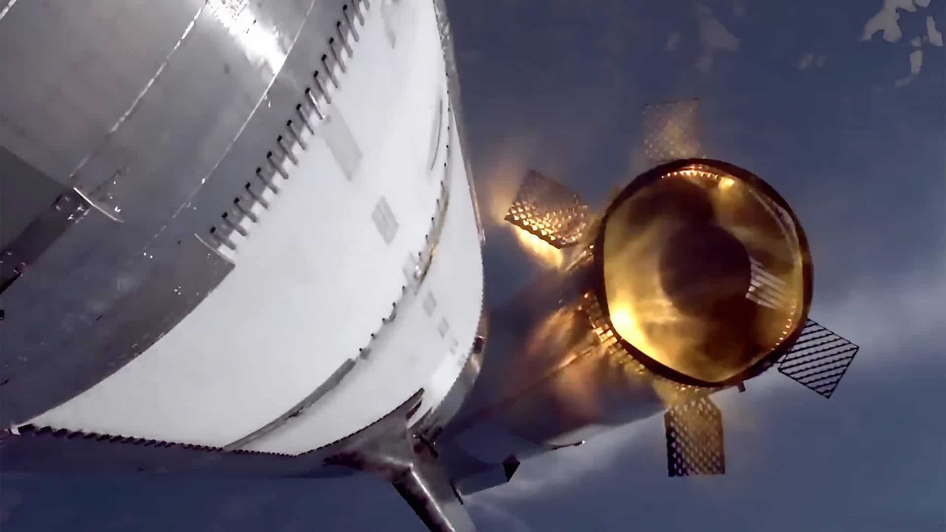 Captura de tela da transmissão ao vivo do sétimo voo de teste do Starship mostra a visão de uma câmera traseira a bordo do estágio superior. O propulsor Super Heavy, com suas quatro aletas de grade estendidas, é visto momentos após a separação dos estágios
