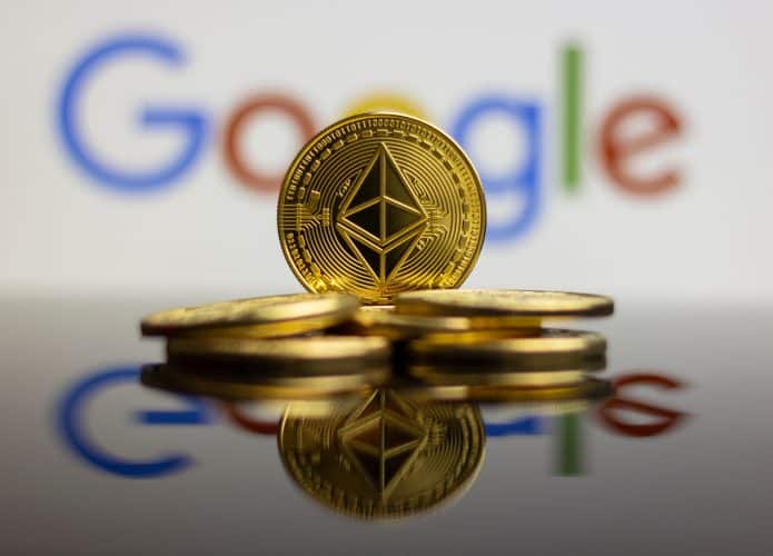 À frente, moedas em um montinho; atrás, logo do Google desfocado