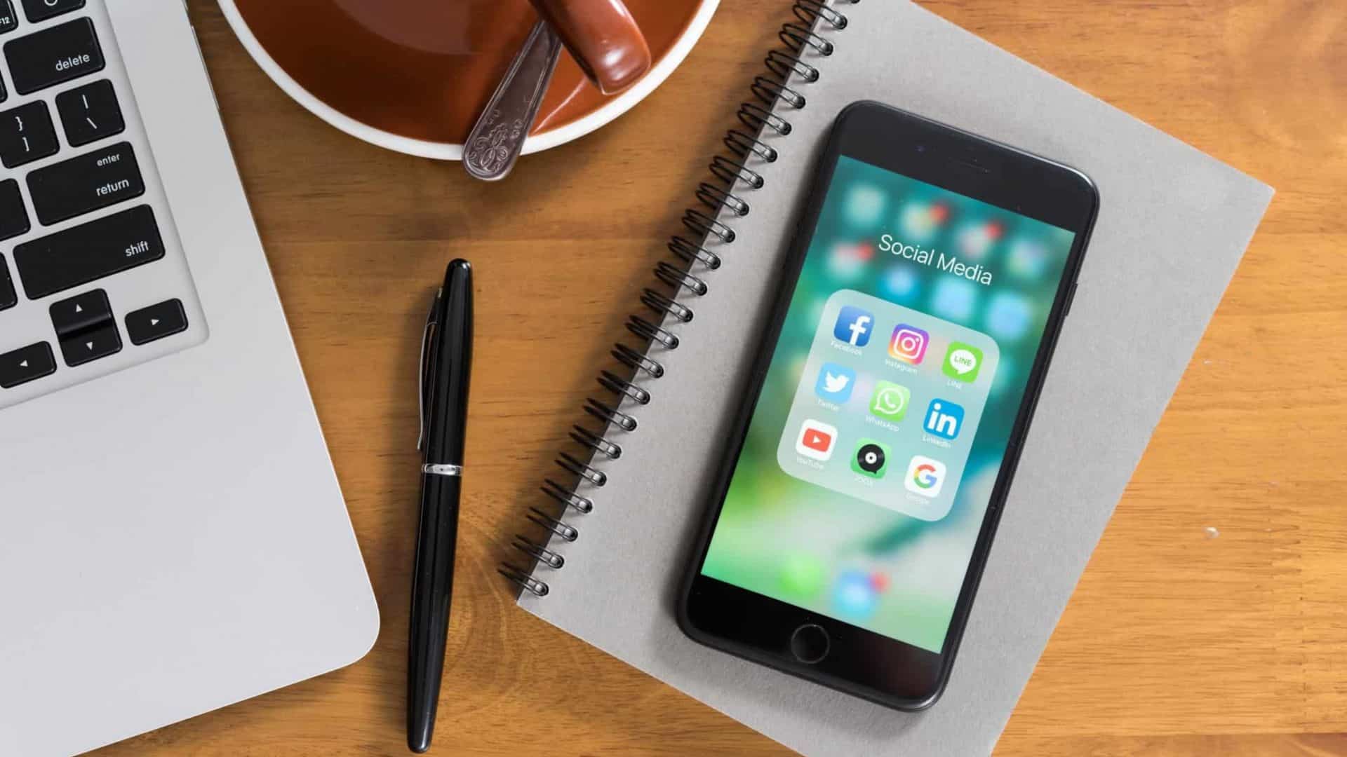 iPhone com aplicativos abertos na tela em cima de um caderno