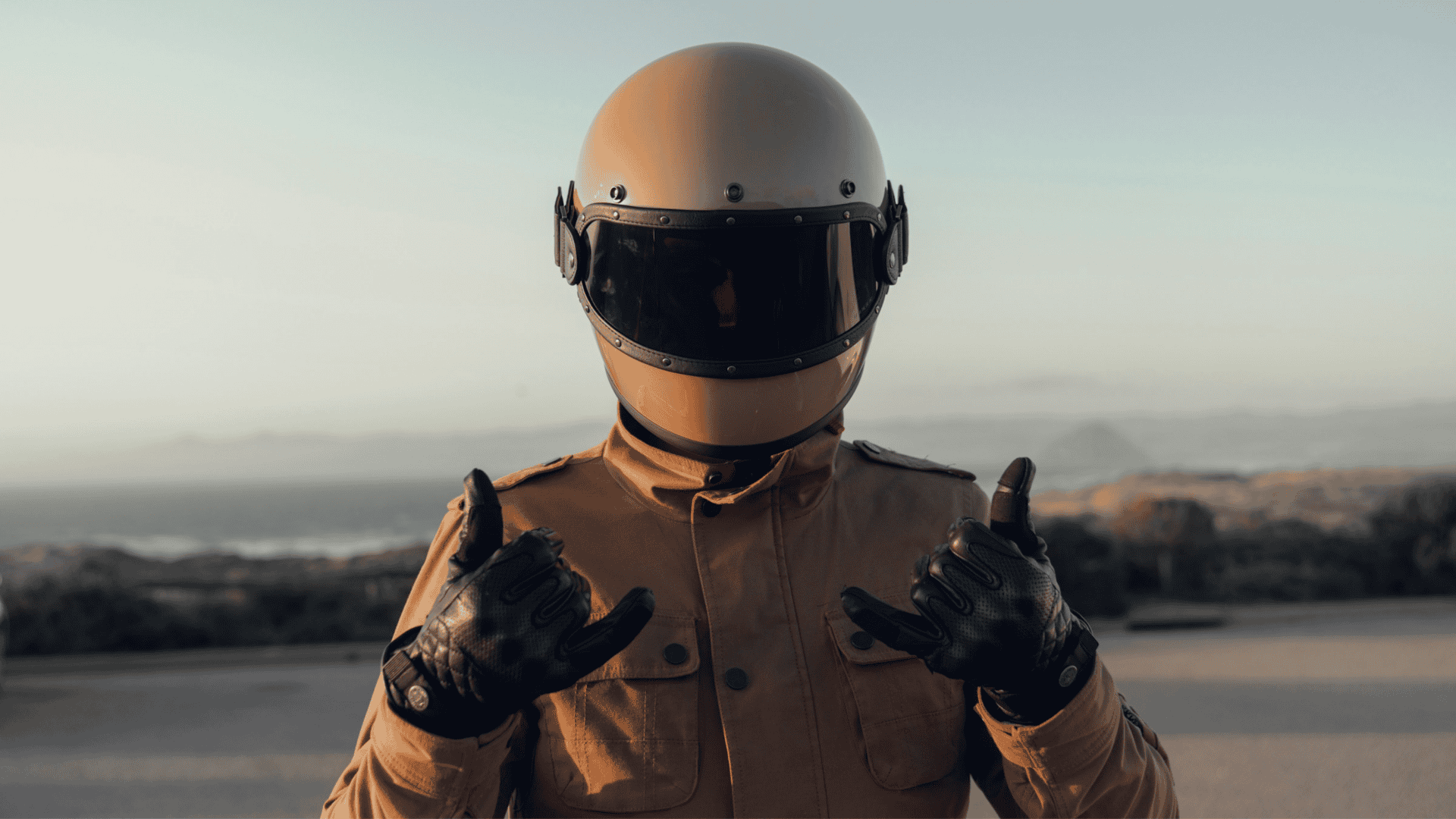 Motociclista pousando para foto em uma região costeira