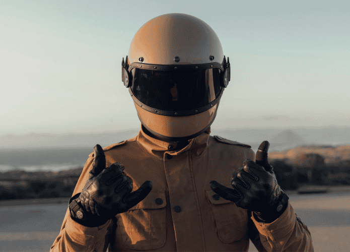 Motociclista pousando para foto em uma região costeira