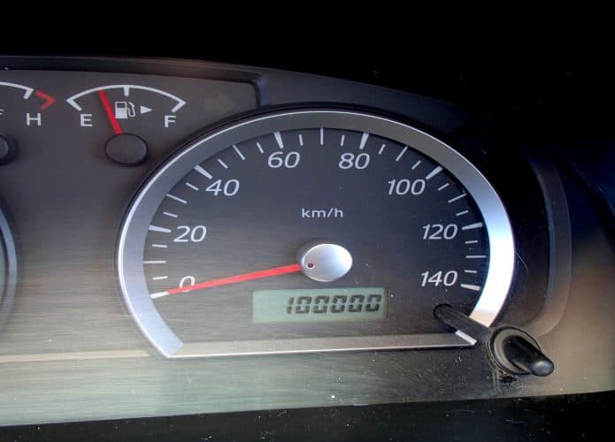 Imagem mostra painel do carro com odômetro mostrando 100.000 km de quilometragem