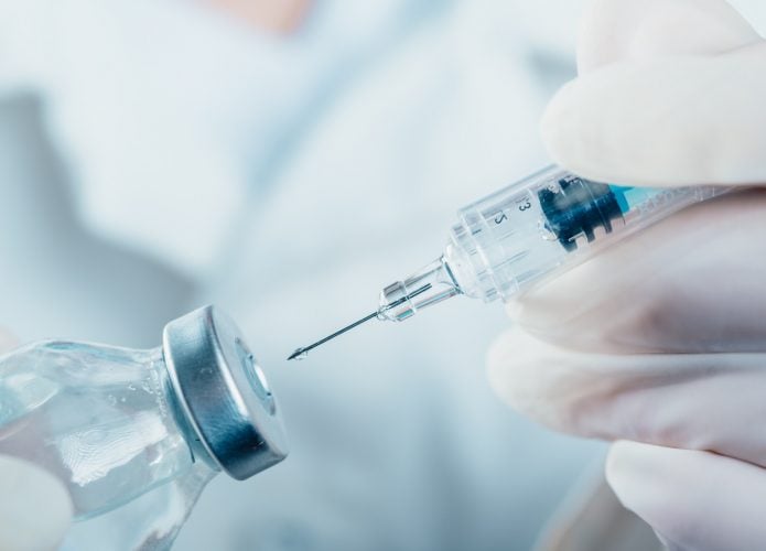 Médico segurando uma seringa com um frasco de vacina