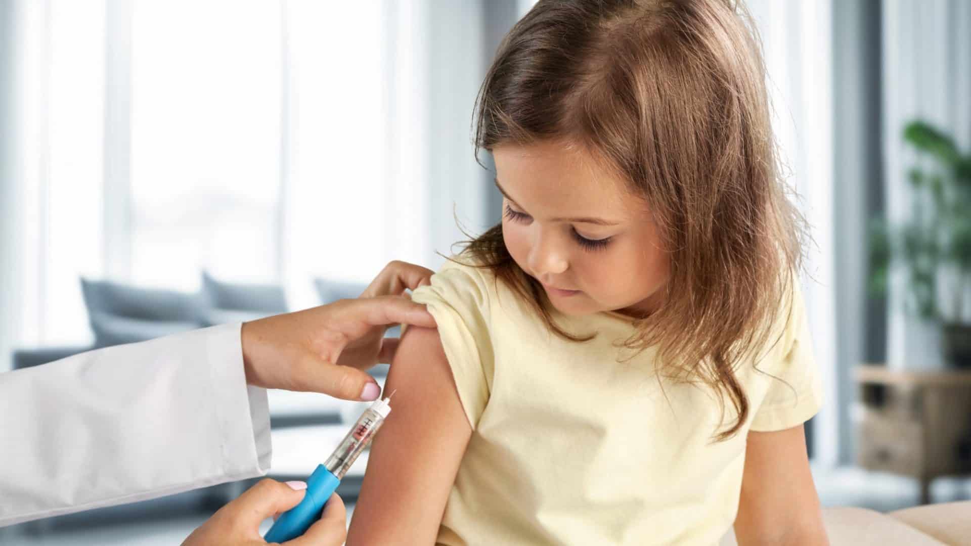 Médico pediatra aplicando vacina em criança