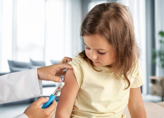 Médico pediatra aplicando vacina em criança
