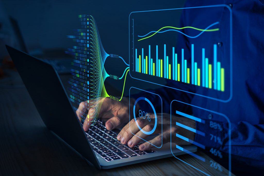 Pessoa digitando em um teclado de notebook com gráficas pairando à sua frente