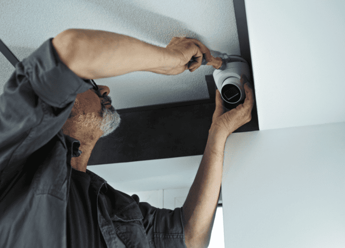Homem instalando uma câmera de segurança