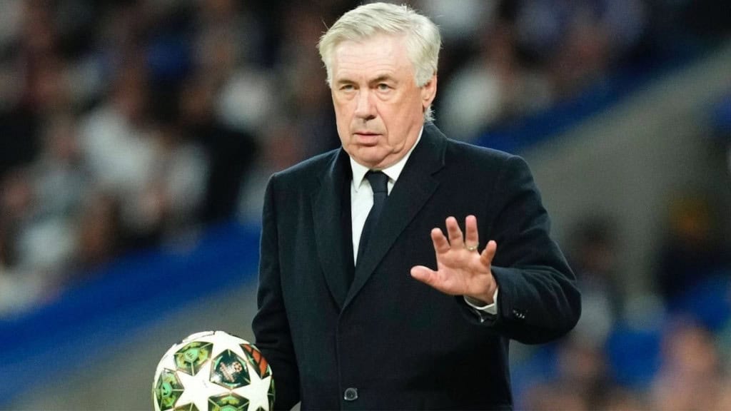Carlo Ancelotti com mão estendida e expressão séria