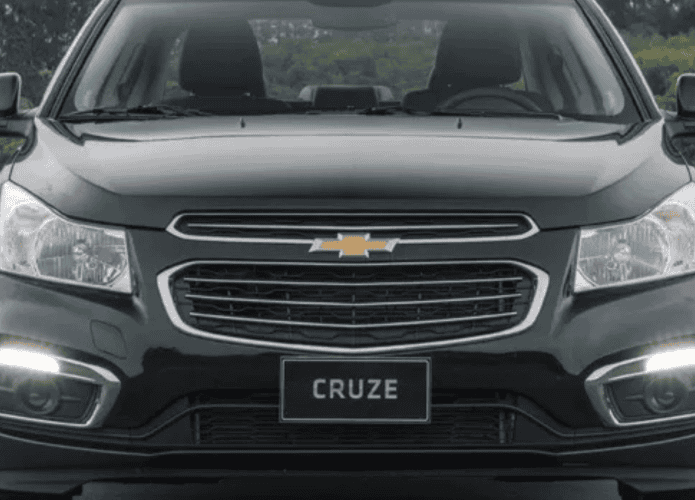 carro sedan preto visto de frente, estacionado numa estrada de terra