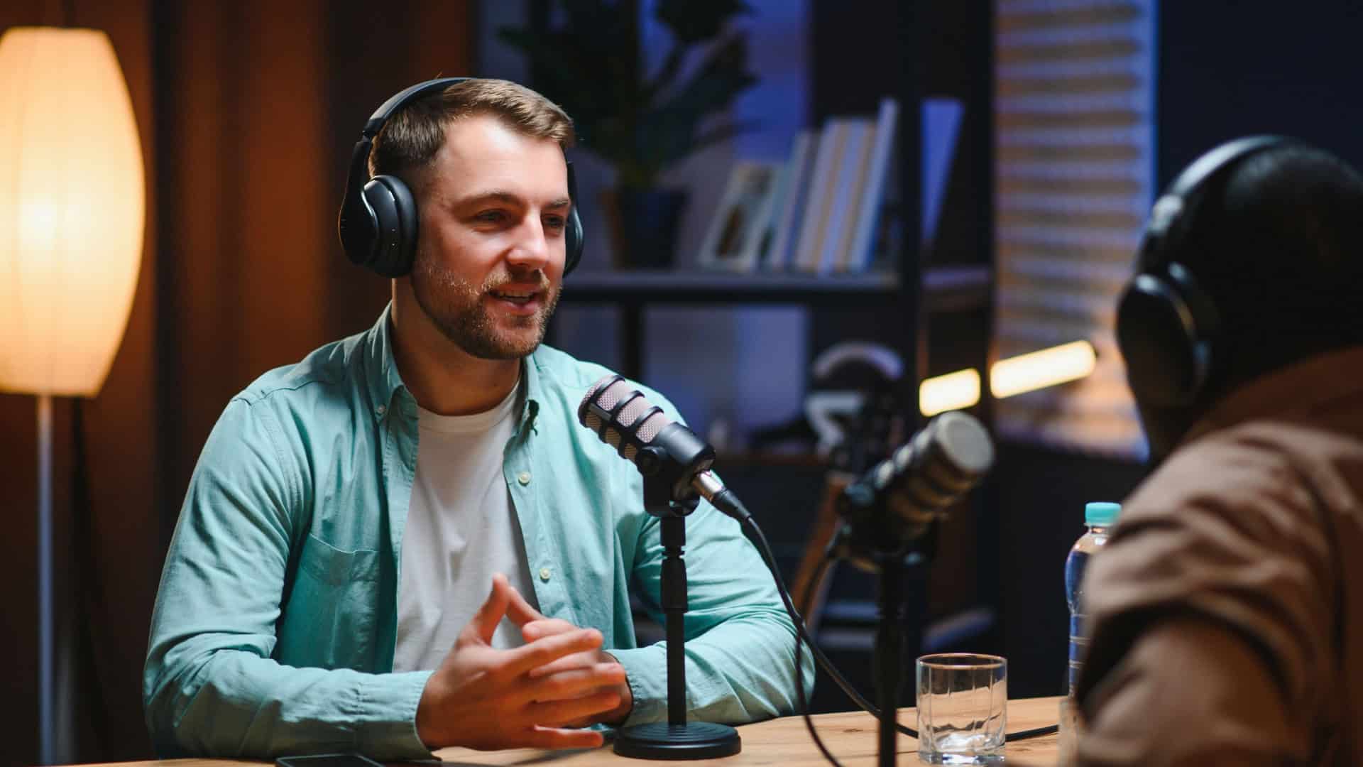 Podcasters desfrutando de conversas felizes com ouvintes on-line em estúdio, cobrindo uma ampla gama de assuntos.