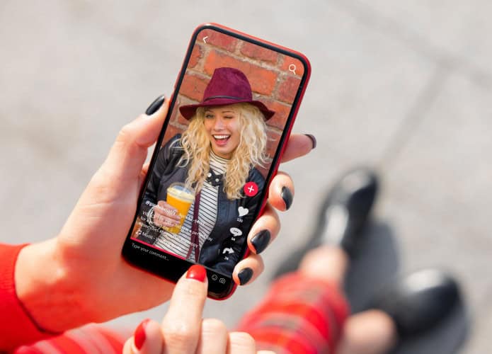 Pessoa assistindo vídeo de influencer do TikTok no celular