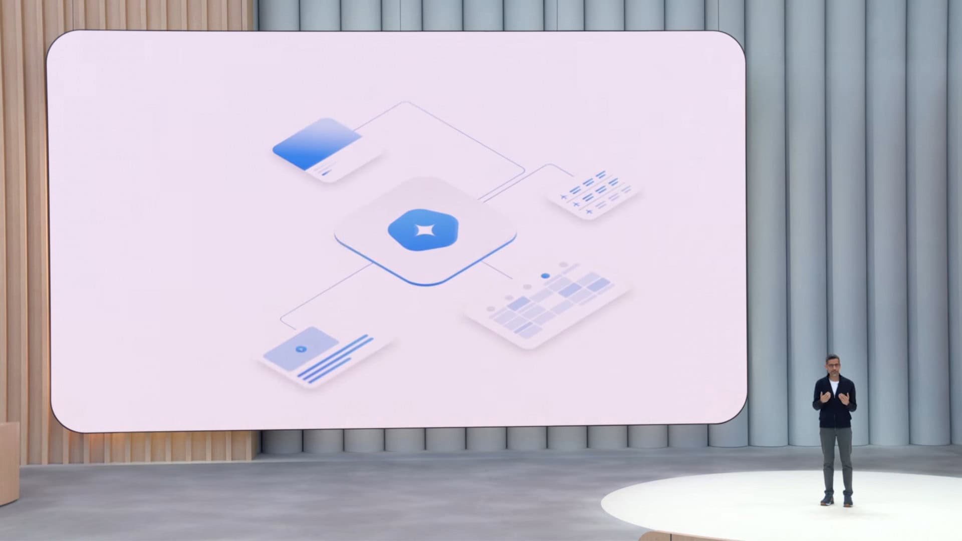 CEO do Google, Sundar Pichai, ao lado de telão com ilustração sobre Modo Agente no aplicativo do Gemini