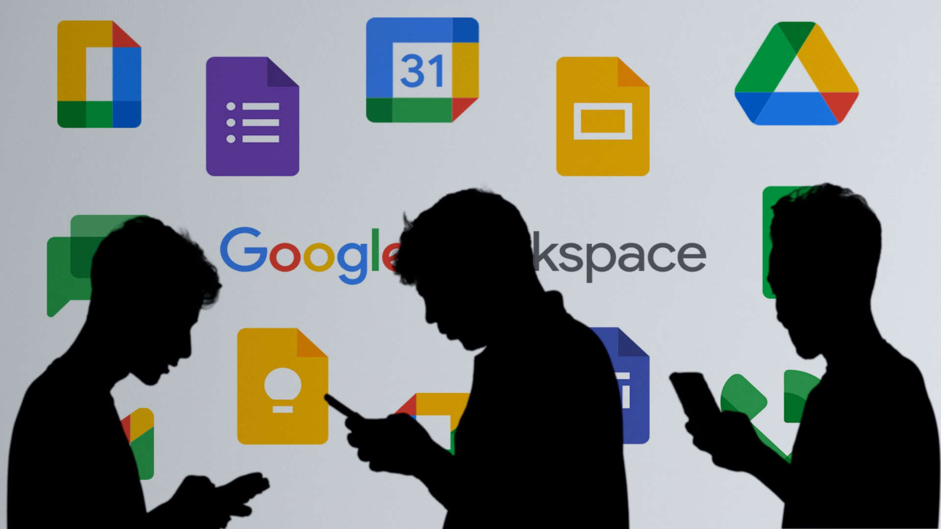 Silhueta de pessoas usando celular na frente de ícones de aplicativos do Google Workspace, como Drive, Keep e Slides