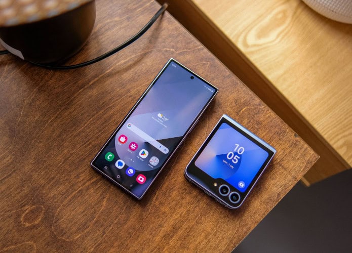 Galaxy Z Fold 6 e Galaxy Z Flip 6 em cima de mesa de madeira com telas acesas mostrando One UI