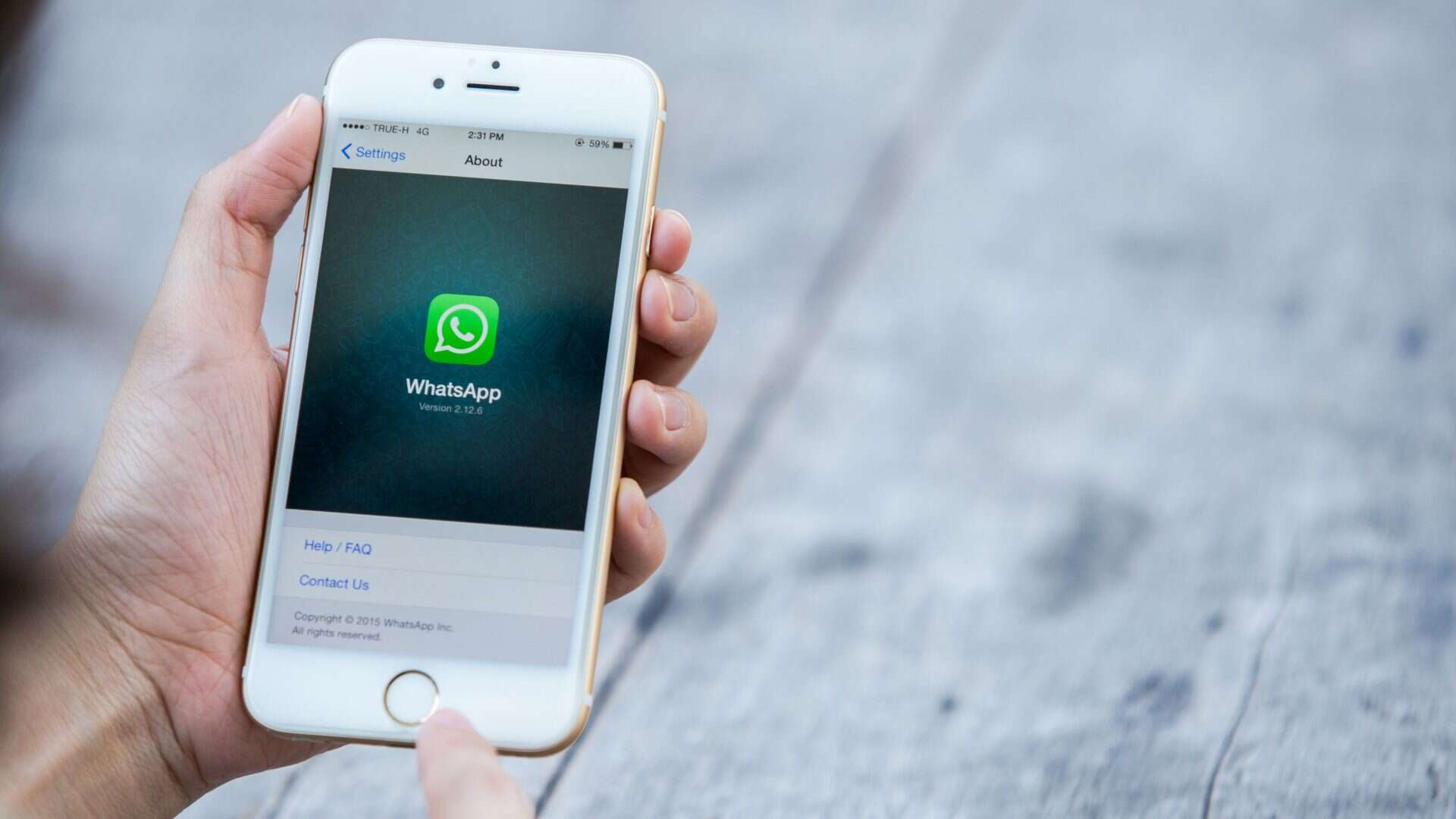 Pessoa acessando página sobre WhatsApp num iPhone 6
