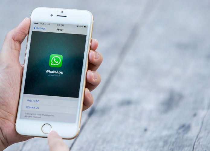 Pessoa acessando página sobre WhatsApp num iPhone 6