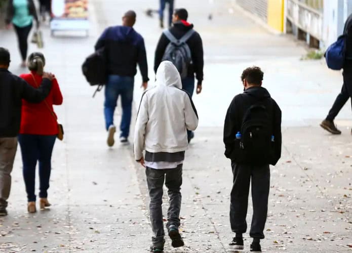 Pessoas andando agasalhadas na rua em dia frio