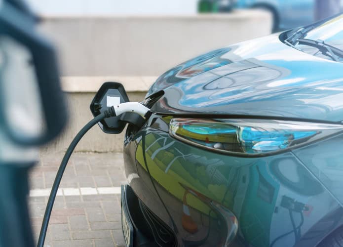 imagem mostra um carro elétrico sendo recarregado em um posto