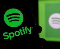 Logo do Spotify em um smartphone e ao fundo