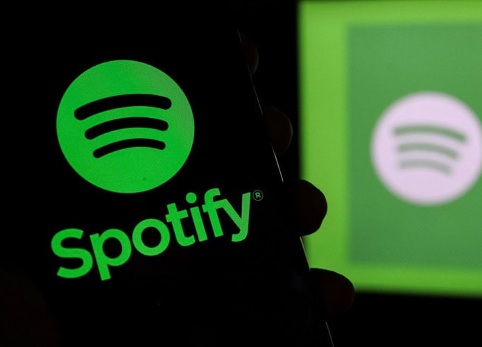 Logo do Spotify em um smartphone e ao fundo