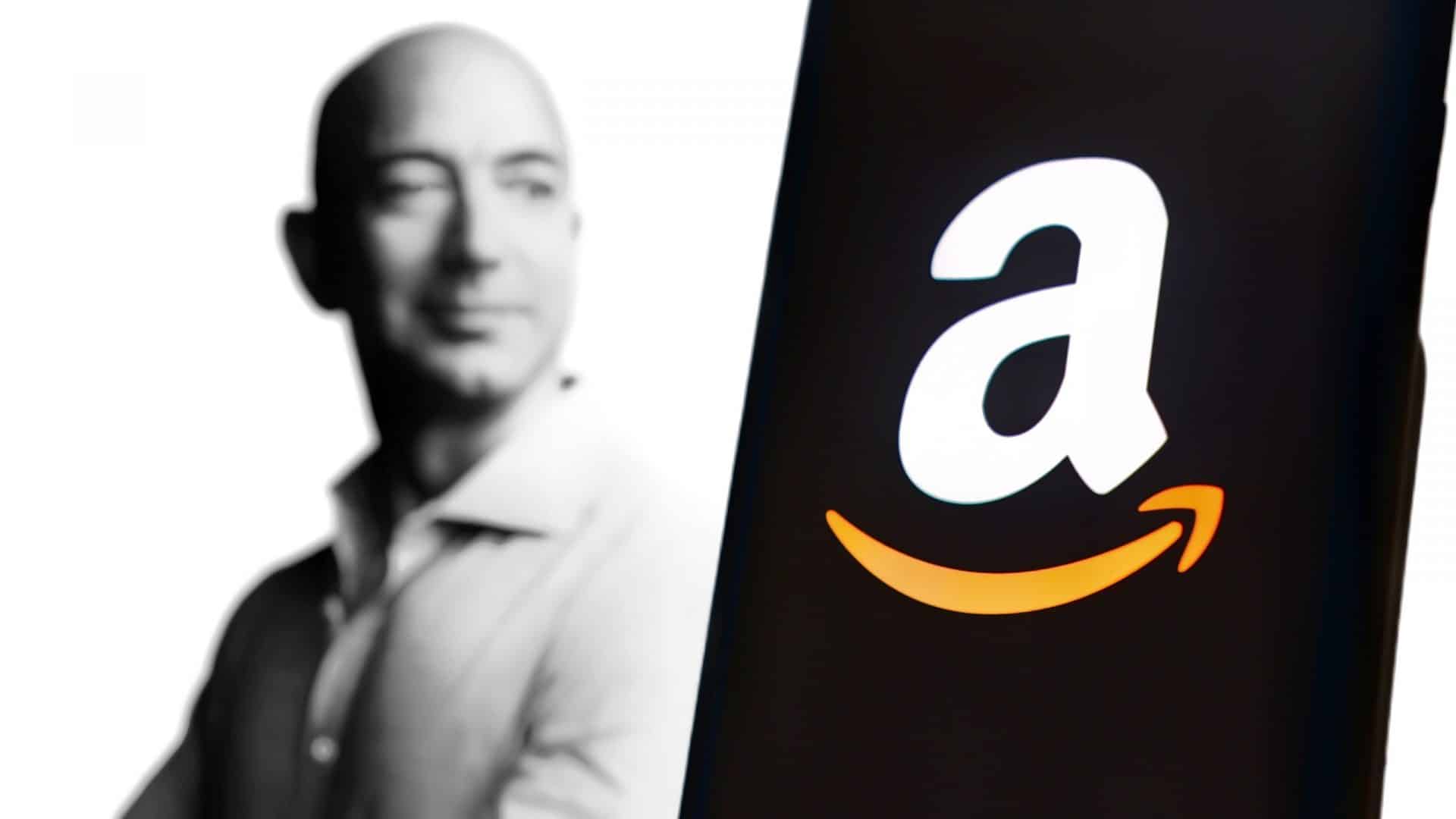 Ao fundo, foto em preto e branco de Jeff Bezos; à frente, logo da Amazon na tela de um smartphone