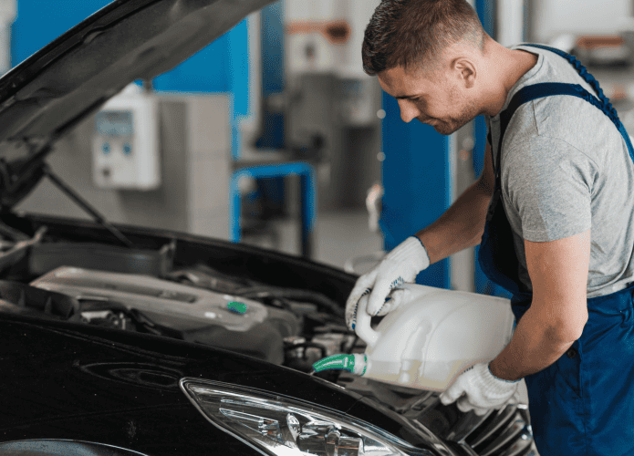 Mecânico fazendo a lubrificação do motor do veículo