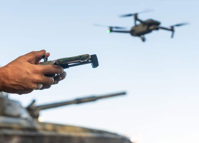 Imagem mostra mãos de militar controlando um drone