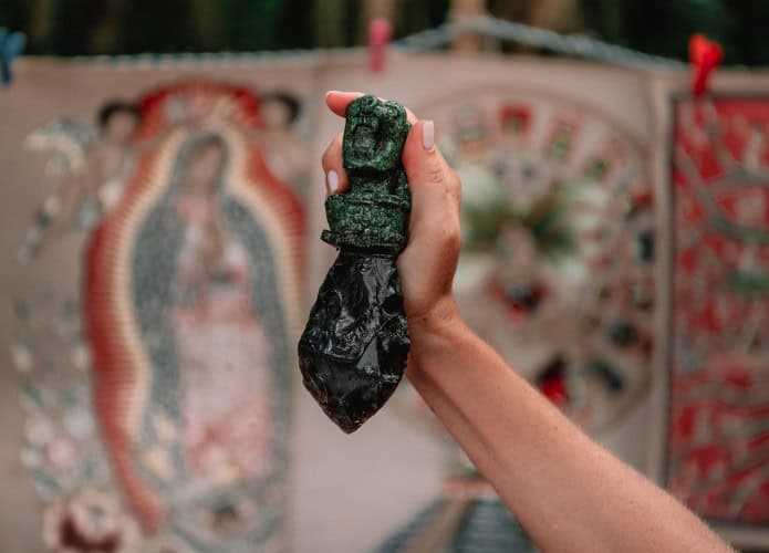 Faca azteca utilizada em sacrifícios segurada por uma mão feminina